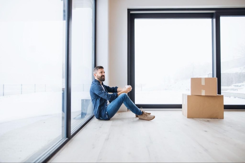 Man sitting with moving boxes while preparing to move into an apartment in Dallas